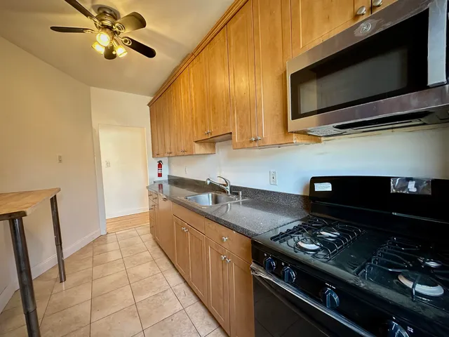 a kitchen with stainless steel appliances granite countertop a sink and a stove top oven