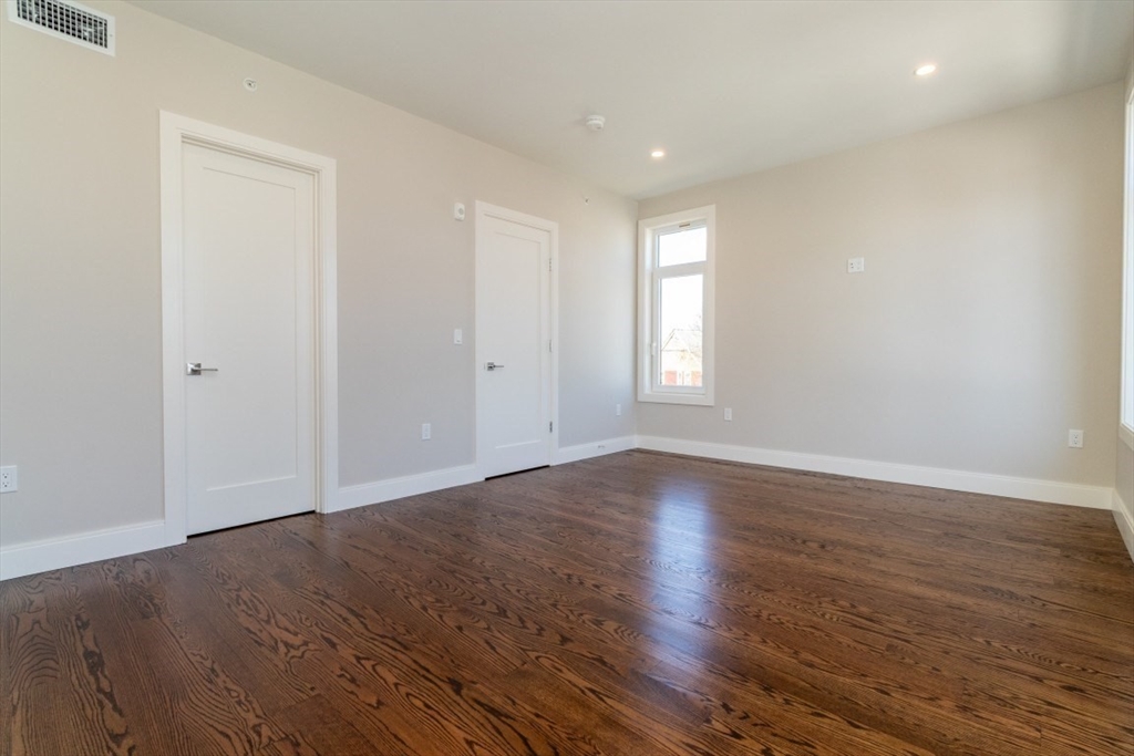 15 Tanglewood Road, Unit A Boston, MA 02126 - Photo 18 of 28 a view of an empty room with wooden floor and window