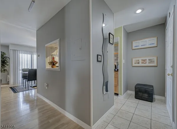 a view of a hallway with wooden floor and a living room