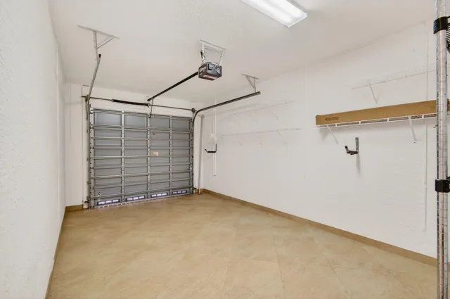 a patio with a table and chairs and potted plants