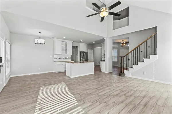 a view of a kitchen with wooden floor and a ceiling fan