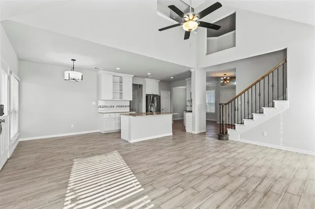 a view of a kitchen with wooden floor and a ceiling fan