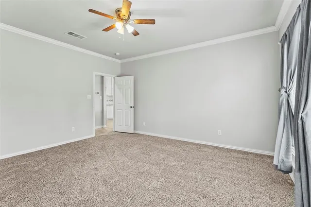 an empty room with closet and a ceiling fan