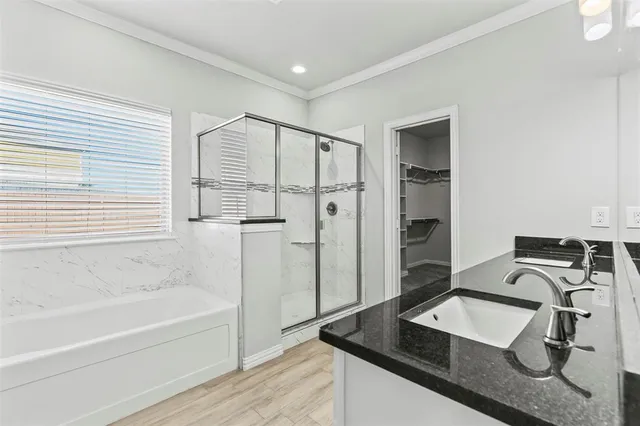 a bathroom with a granite countertop sink a mirror and a bathtub