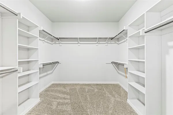 a view of walk in closet with empty racks