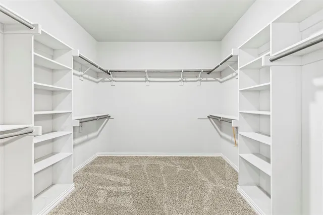 a view of walk in closet with empty racks