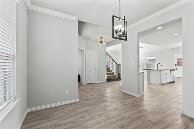a view of a hallway with wooden floor and a kitchen