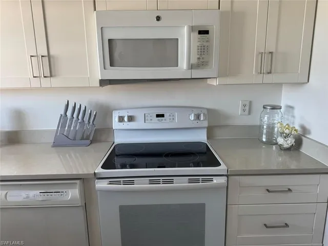 a white stove top oven sitting inside of a kitchen