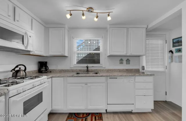 a kitchen with granite countertop a sink stainless steel appliances and cabinets