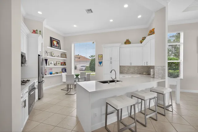 a bathroom with a double vanity sink a mirror a bathtub and next to a window
