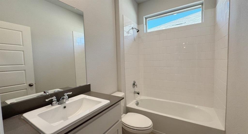 312 Potato Street Keene, TX 76059 - Photo 13 of 21 a bathroom with a toilet a sink and a bathtub