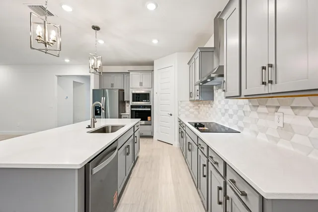 a kitchen with a stove sink and cabinets
