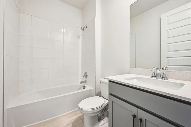 a bathroom with a sink toilet vanity and shower