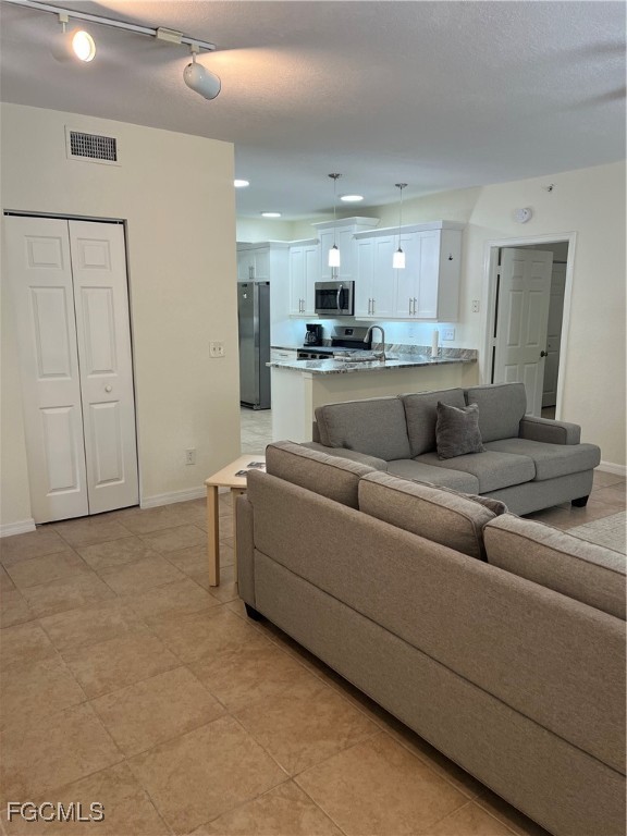 6401 Aragon Way, Unit 107 Fort Myers, FL 33966 - Photo 3 of 28 a living room with furniture and a view of kitchen