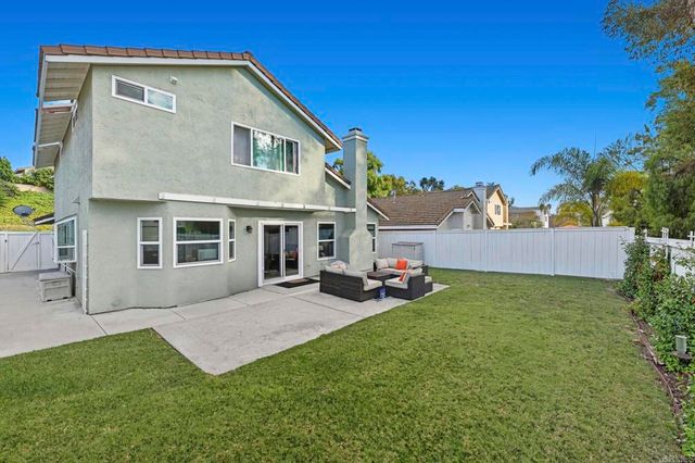 a view of a house with a patio and a yard