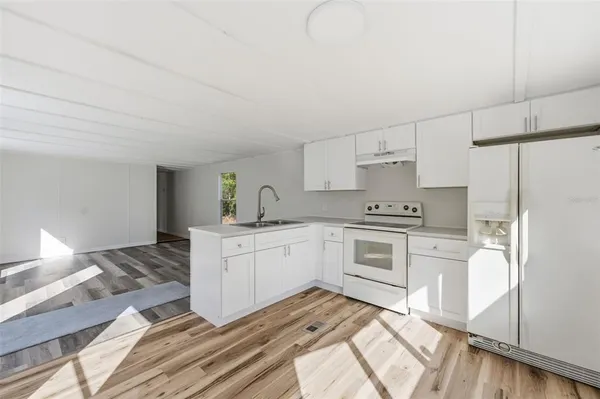 a kitchen with white cabinets and white appliances