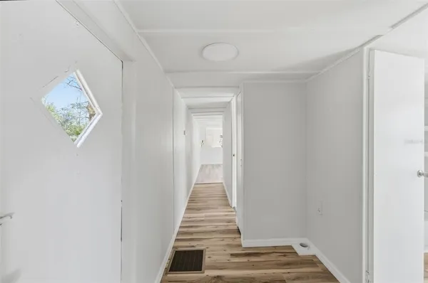 a view of a hallway with wooden floor and entryway