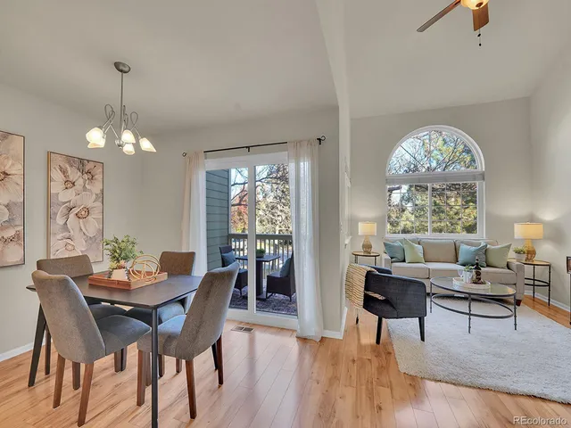 a dining room with wooden floor a chandelier a wooden table and chairs