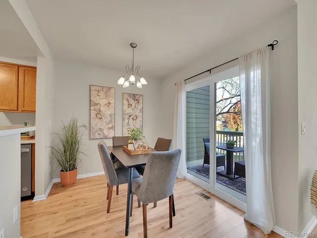 a dining room with furniture a chandelier and wooden floor