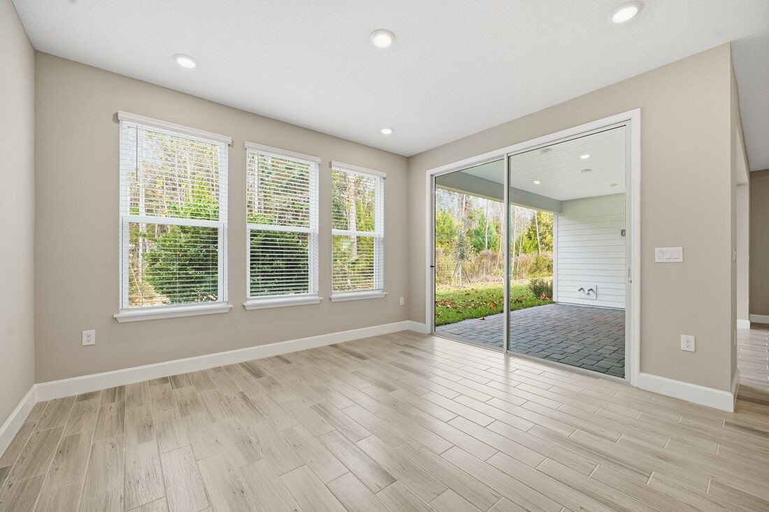 86049 Living Waters Run Yulee, FL 32097 - Photo 11 of 36 a view of an empty room with wooden floor and a window