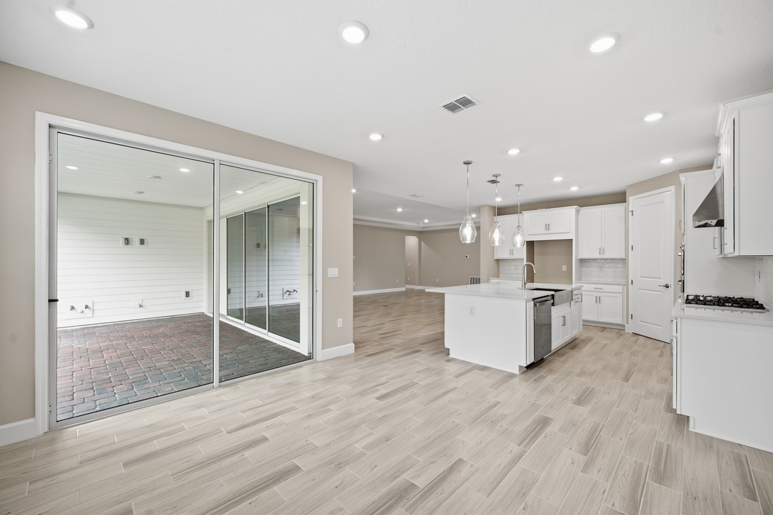 86049 Living Waters Run Yulee, FL 32097 - Photo 12 of 36 a large kitchen with kitchen island a white counter space a stove and a refrigerator