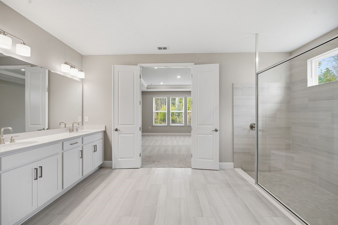 86049 Living Waters Run Yulee, FL 32097 - Photo 19 of 36 a bathroom with a double vanity sink toilet and shower