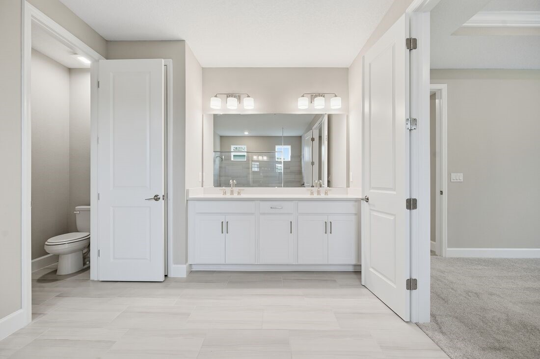 86049 Living Waters Run Yulee, FL 32097 - Photo 20 of 36 a bathroom with a granite countertop toilet a sink and a mirror