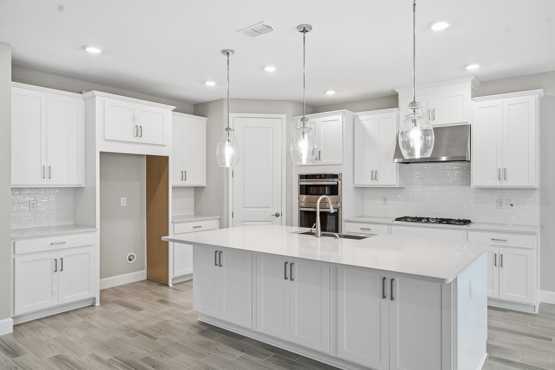 86049 Living Waters Run Yulee, FL 32097 - Photo 2 of 36 a kitchen with stainless steel appliances granite countertop a sink a stove a refrigerator a center island and cabinets