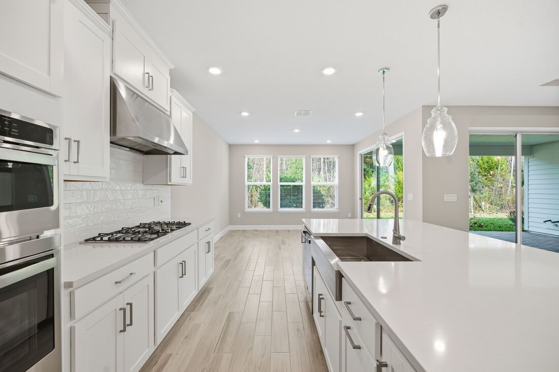 86049 Living Waters Run Yulee, FL 32097 - Photo 3 of 36 a kitchen with granite countertop a stove and a sink