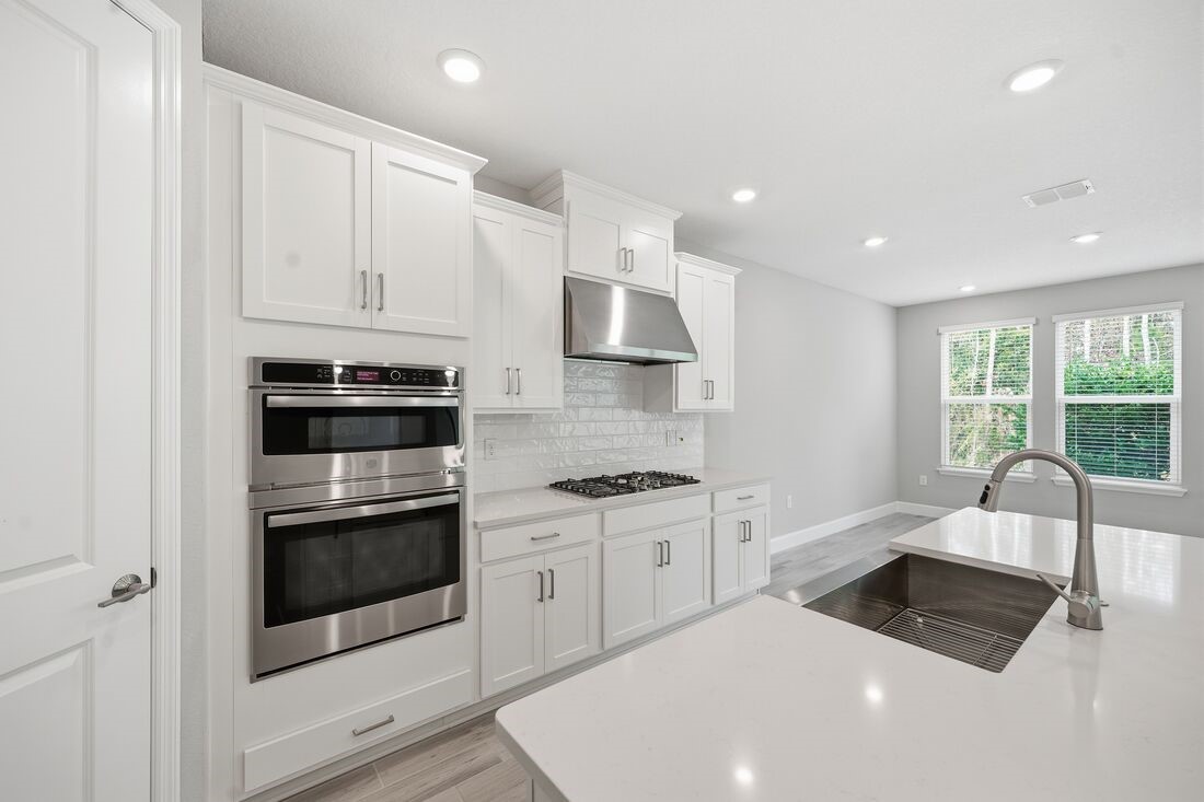 86049 Living Waters Run Yulee, FL 32097 - Photo 4 of 36 a kitchen with stainless steel appliances granite countertop a stove a sink and a microwave
