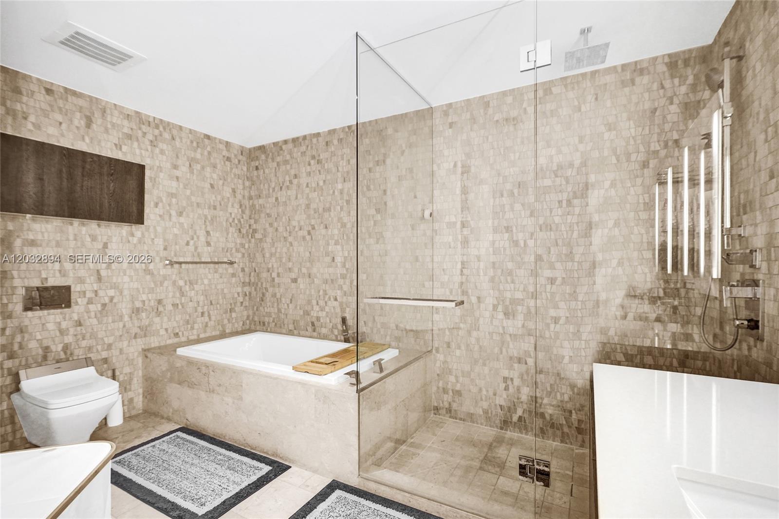 88 Southwest 7th Street, Unit 2210 Miami, FL 33130 - Photo 12 of 24 Primary bath with dual vanity, illuminated mirrors, glass shower and stone finishes.