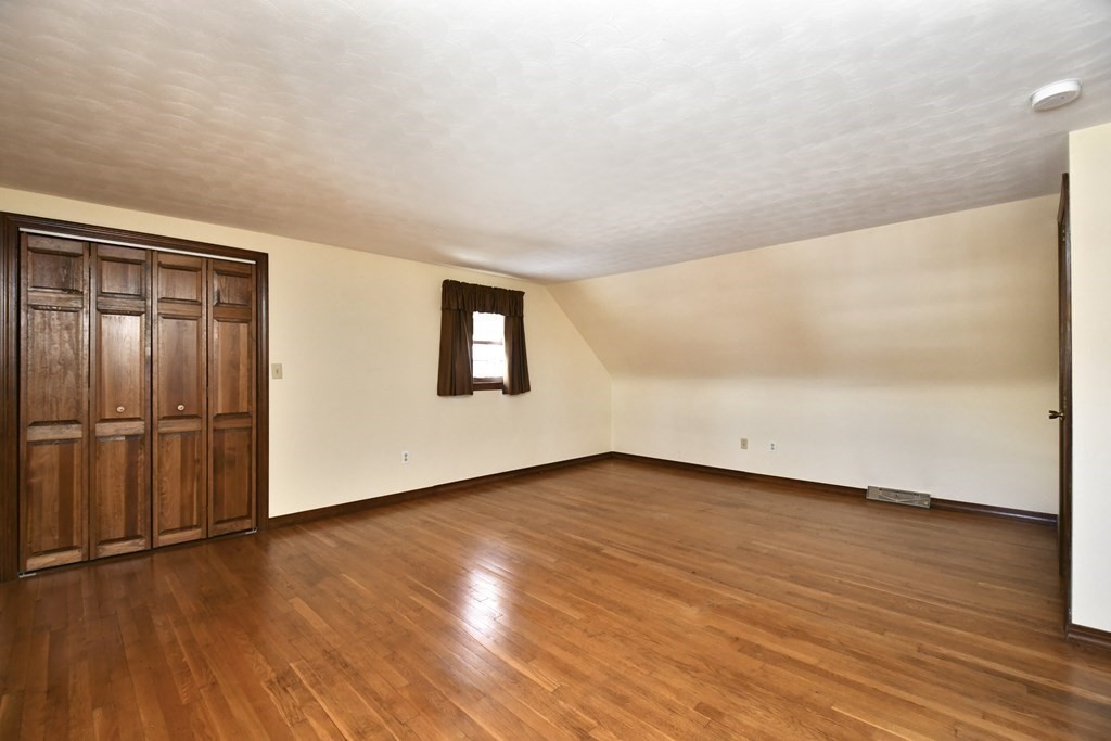 72 Old Bolton Road Hudson, MA 01749 - Photo 19 of 42 a view of an empty room with wooden floor and a window