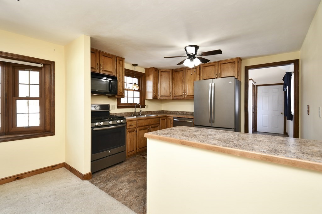 72 Old Bolton Road Hudson, MA 01749 - Photo 8 of 42 a kitchen with stainless steel appliances granite countertop a refrigerator a stove a sink and a microwave