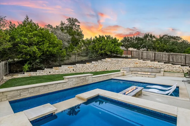 a view of sitting area with swimming pool and trees in the background