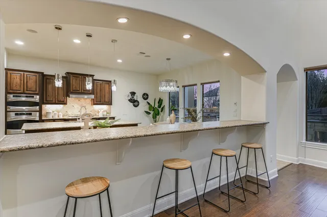 a kitchen with kitchen island granite countertop a sink stove and cabinets