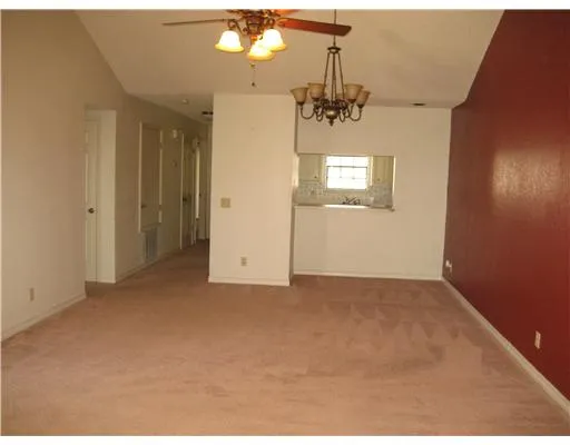 en empty room with windows and ceiling fan