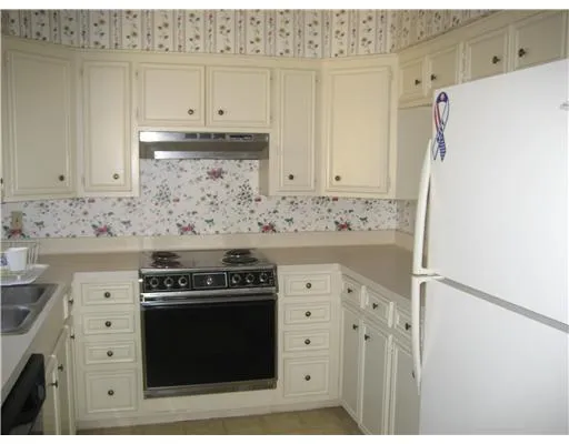 a kitchen with granite countertop white cabinets and refrigerator stove