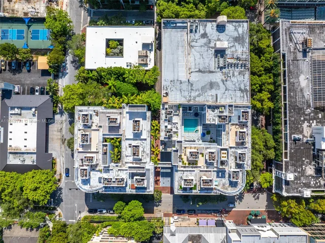 an aerial view of a city with lots of residential buildings ocean and mountain view in back