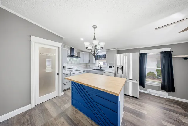 a large kitchen with kitchen island a stove a refrigerator and a sink