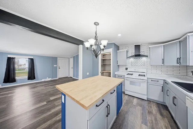 a kitchen that has a lot of white cabinets and stainless steel appliances