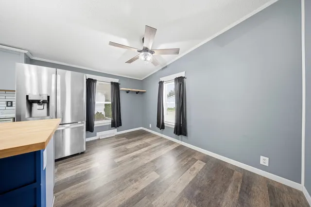 a view of an empty room with window and wooden floor
