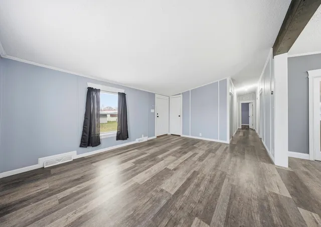 a view of empty room with wooden floor