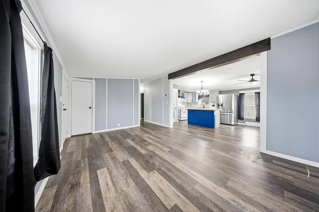 a view of a hallway with wooden floor and kitchen
