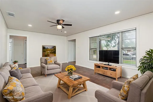 a living room with furniture a flat screen tv and a large window