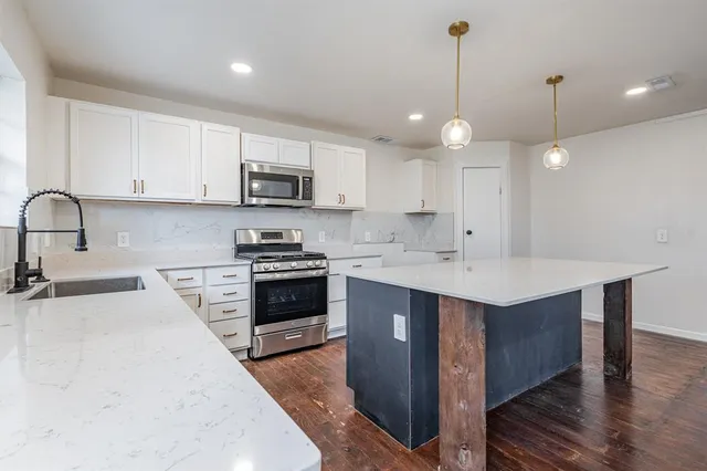 a kitchen with kitchen island a sink stainless steel appliances and cabinets