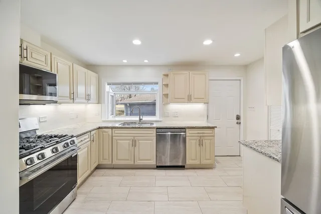 a kitchen with stainless steel appliances a stove a sink and a refrigerator