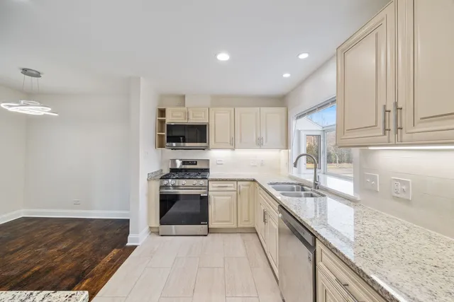 a kitchen with stainless steel appliances granite countertop a sink stove and refrigerator