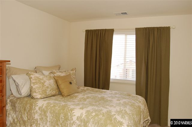 2175 Evergreen Park Drive Reno, NV 89521 - Photo 6 of 9 a large bed in a bedroom next to a window and a wooden floor