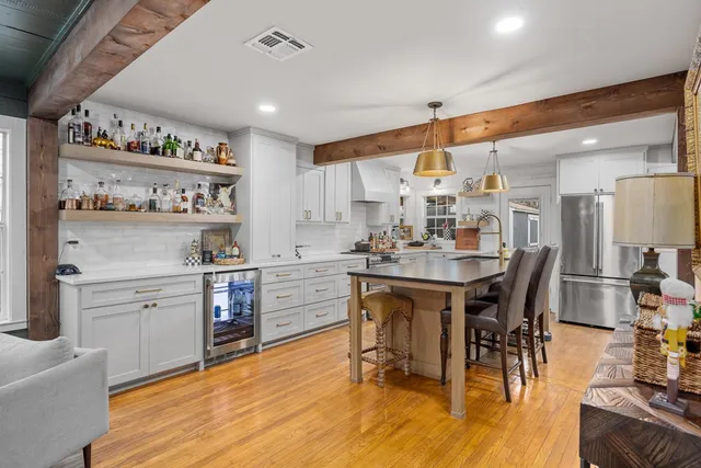 a kitchen with stainless steel appliances kitchen island granite countertop a table chairs sink and cabinets