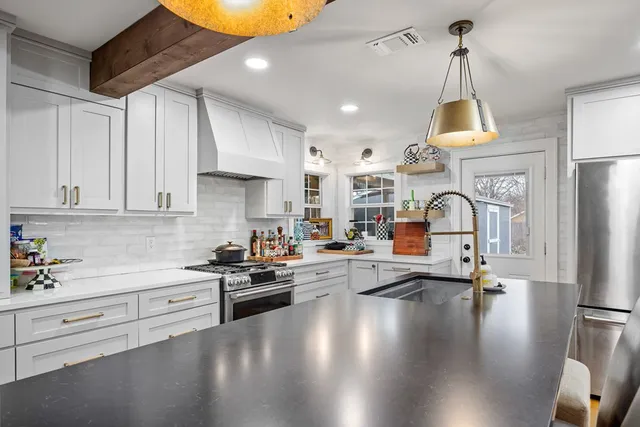 a kitchen with stove and white cabinets